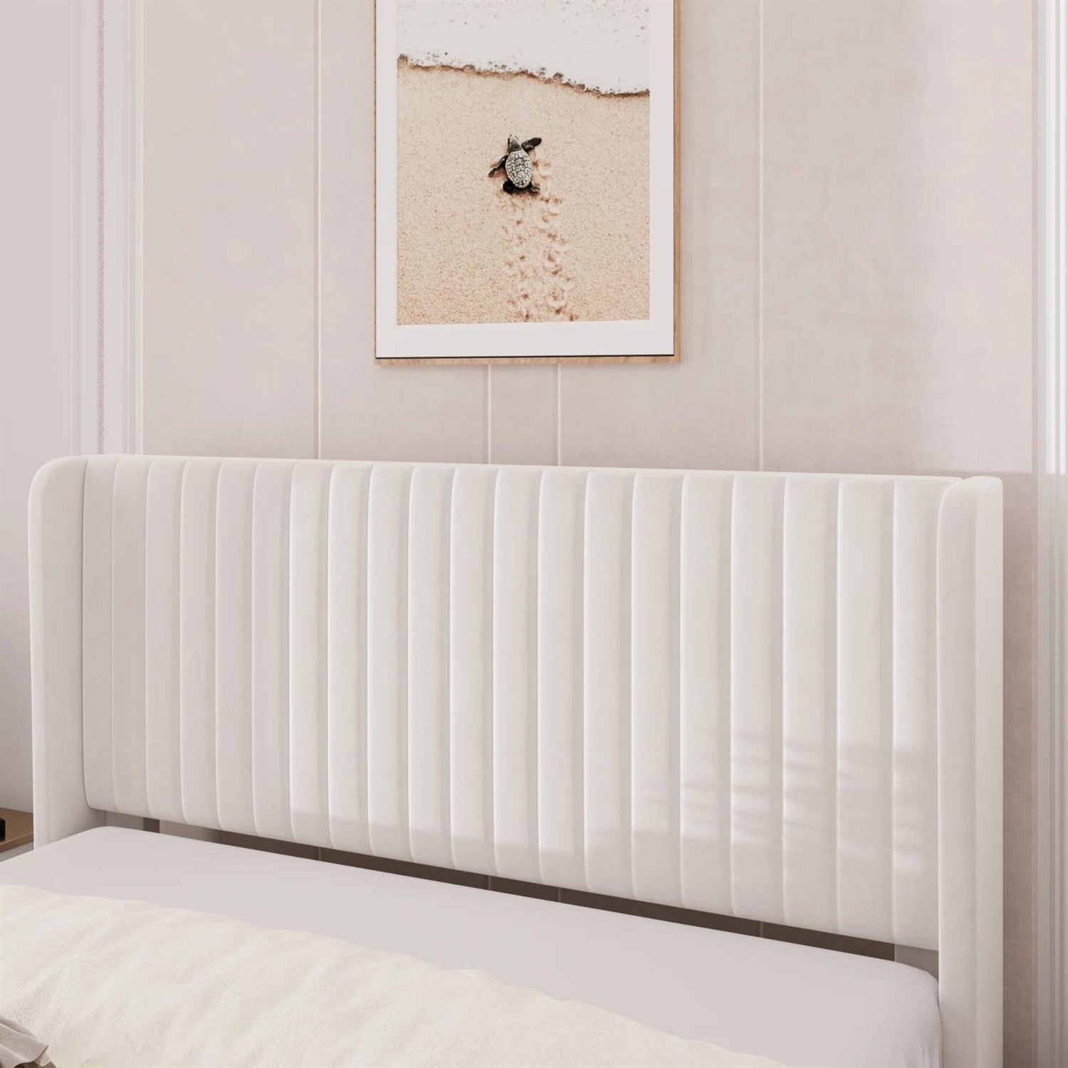 White upholstered headboard against a wall with framed artwork.
