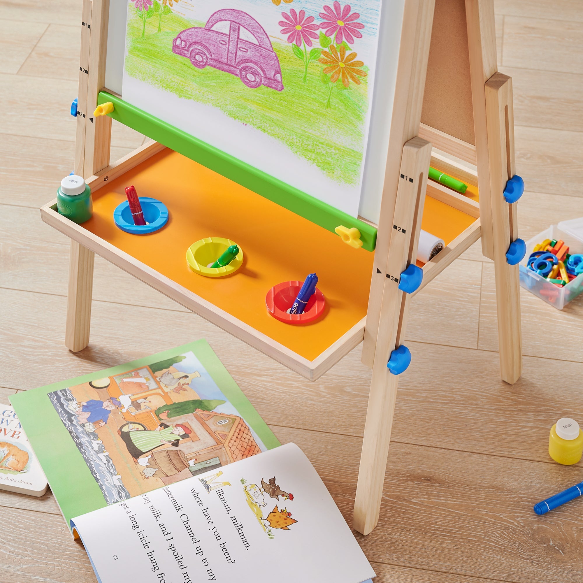 Close-up of bottom storage tray on Tiny Land wooden kids art easel keeping supplies organized