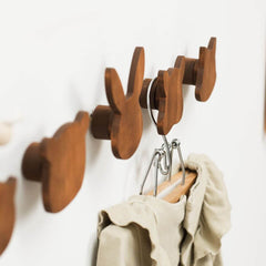 Wooden wall hooks with a beige garment on a white background