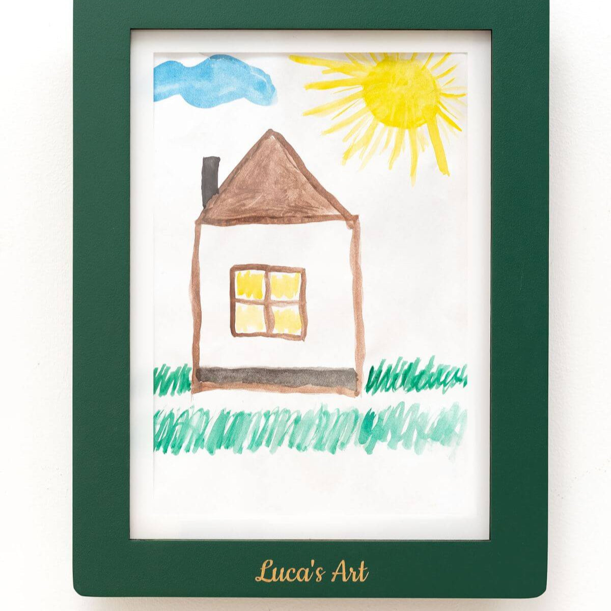 Child's drawing of a house with a sun and clouds in a green frame, labeled 'Luca's Art'.