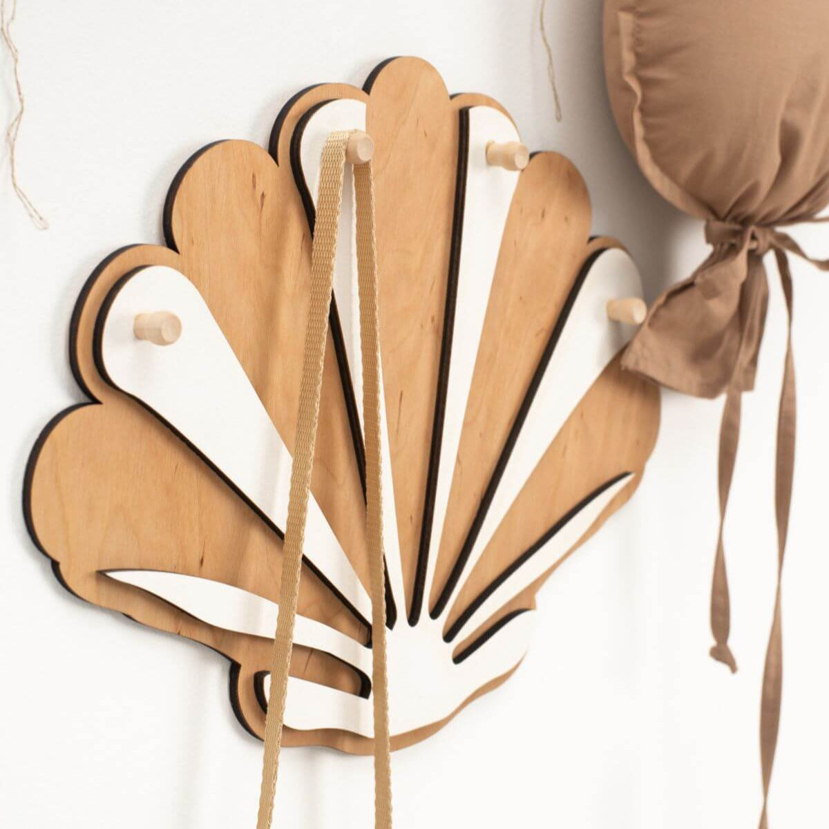 Wooden fan-shaped hook with ribbons on a white background