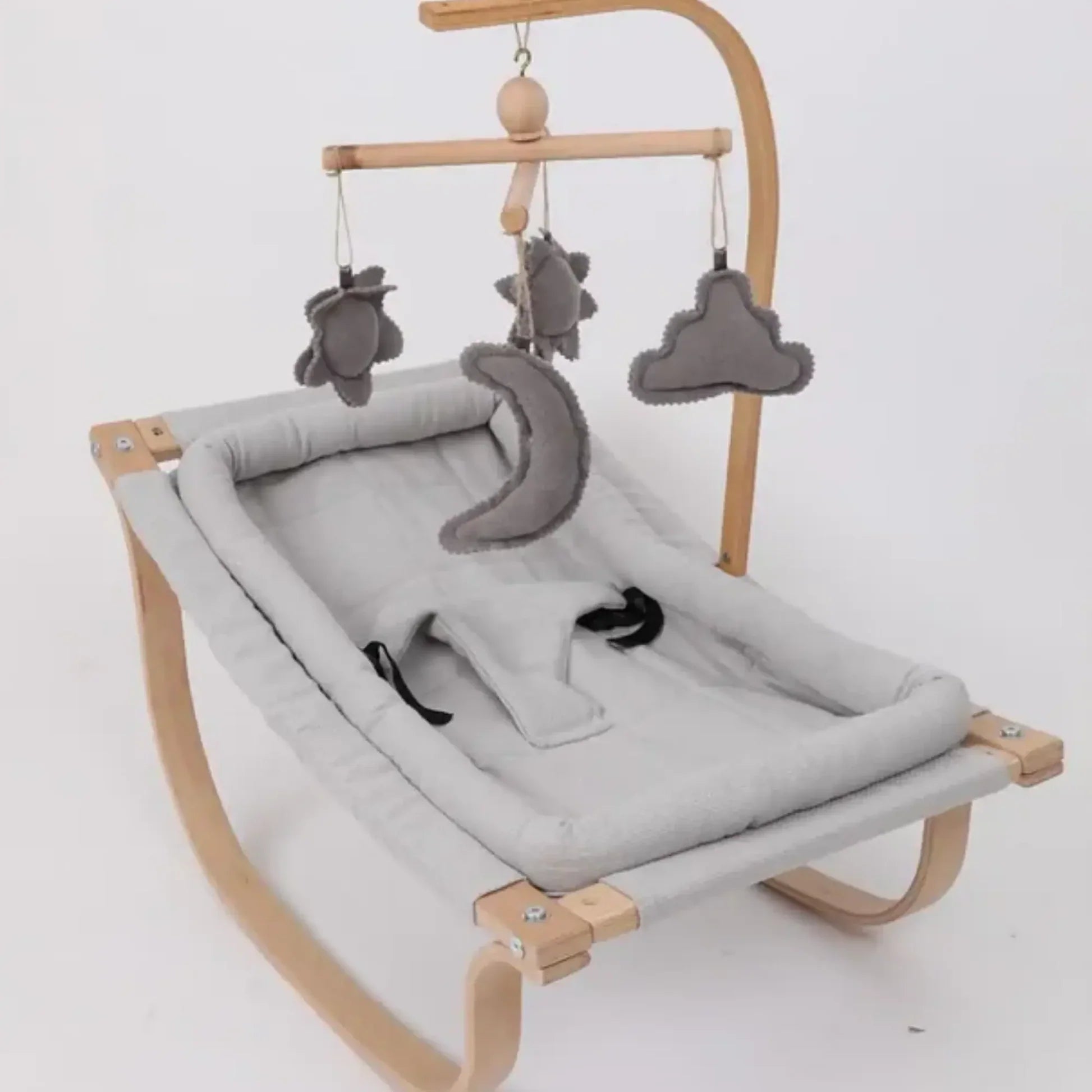 Baby hammock with wooden frame and gray plush toys on a white background