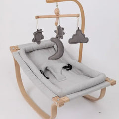 Baby hammock with wooden frame and gray plush toys on a white background