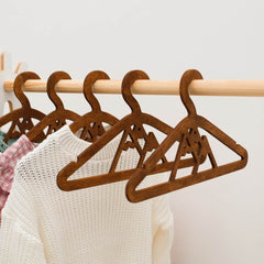 Wooden hangers on a rack with clothes underneath