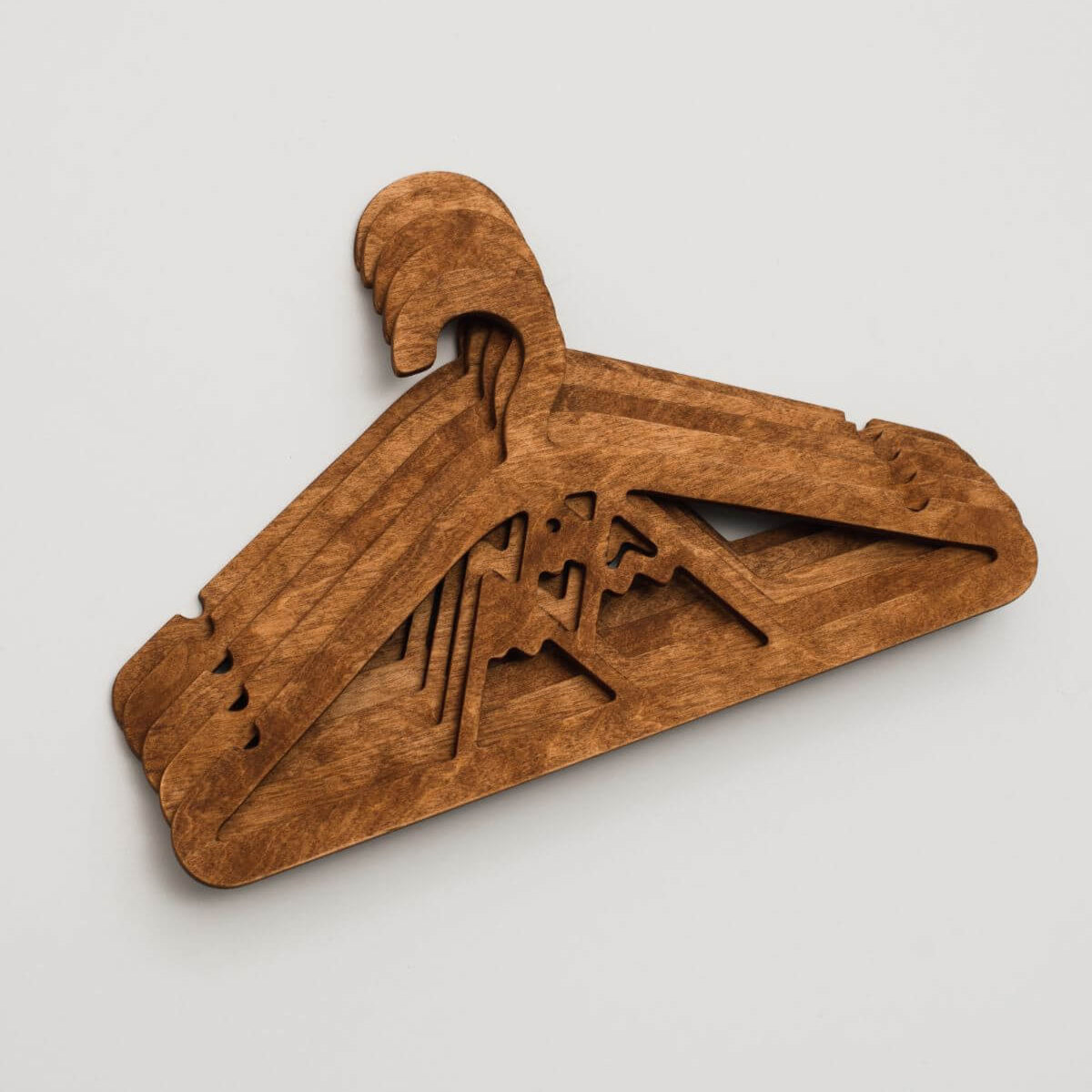 Wooden hanger with a decorative design on a light gray background