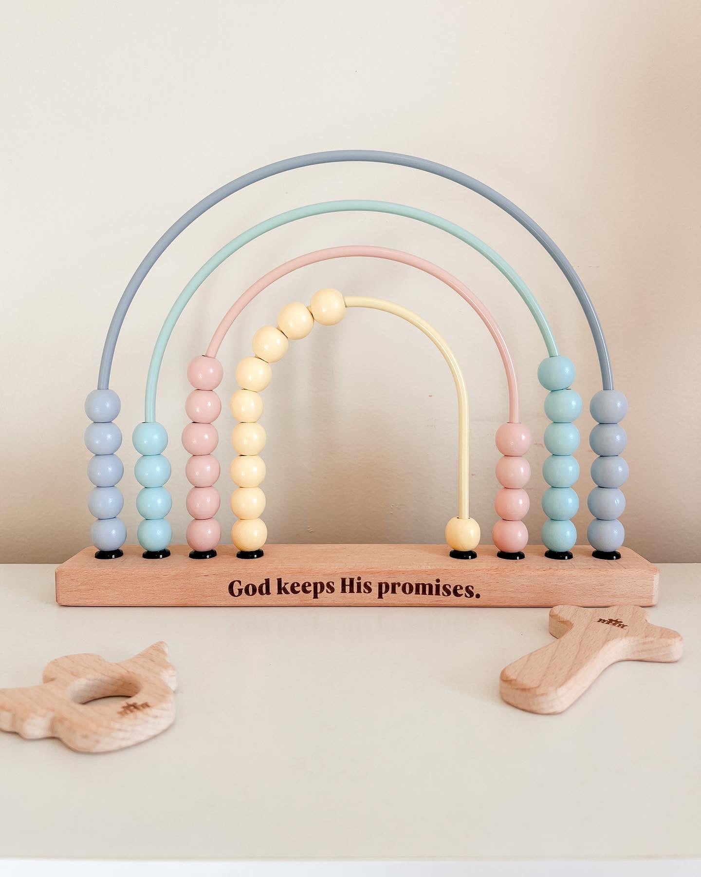 Wooden rainbow abacus with pastel beads and motivational quote on a light background