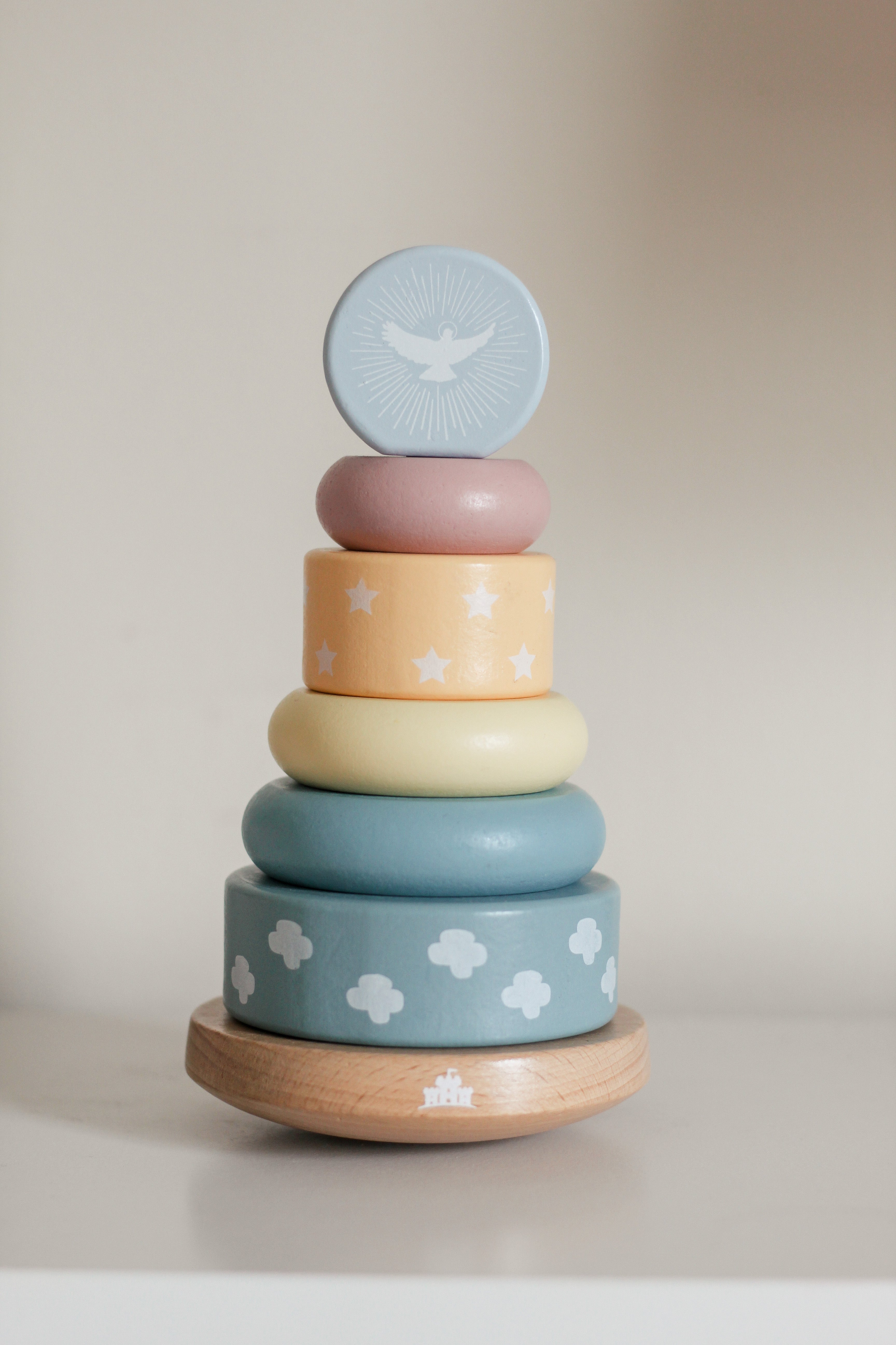 Stack of colorful wooden rings with different patterns on a neutral background