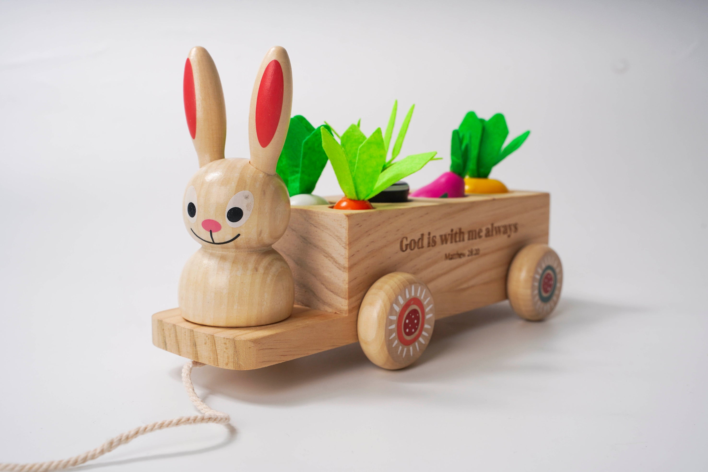 Wooden toy rabbit with a cart carrying vegetables on a white background