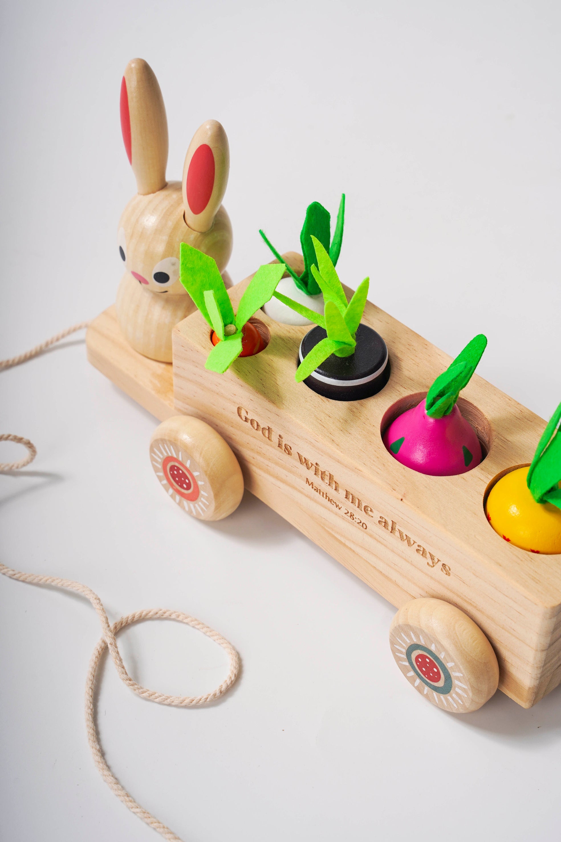 Wooden toy with rabbit figure and colorful wheels on a light background