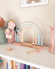 Pastel-colored rainbow abacus on a shelf with decorative items
