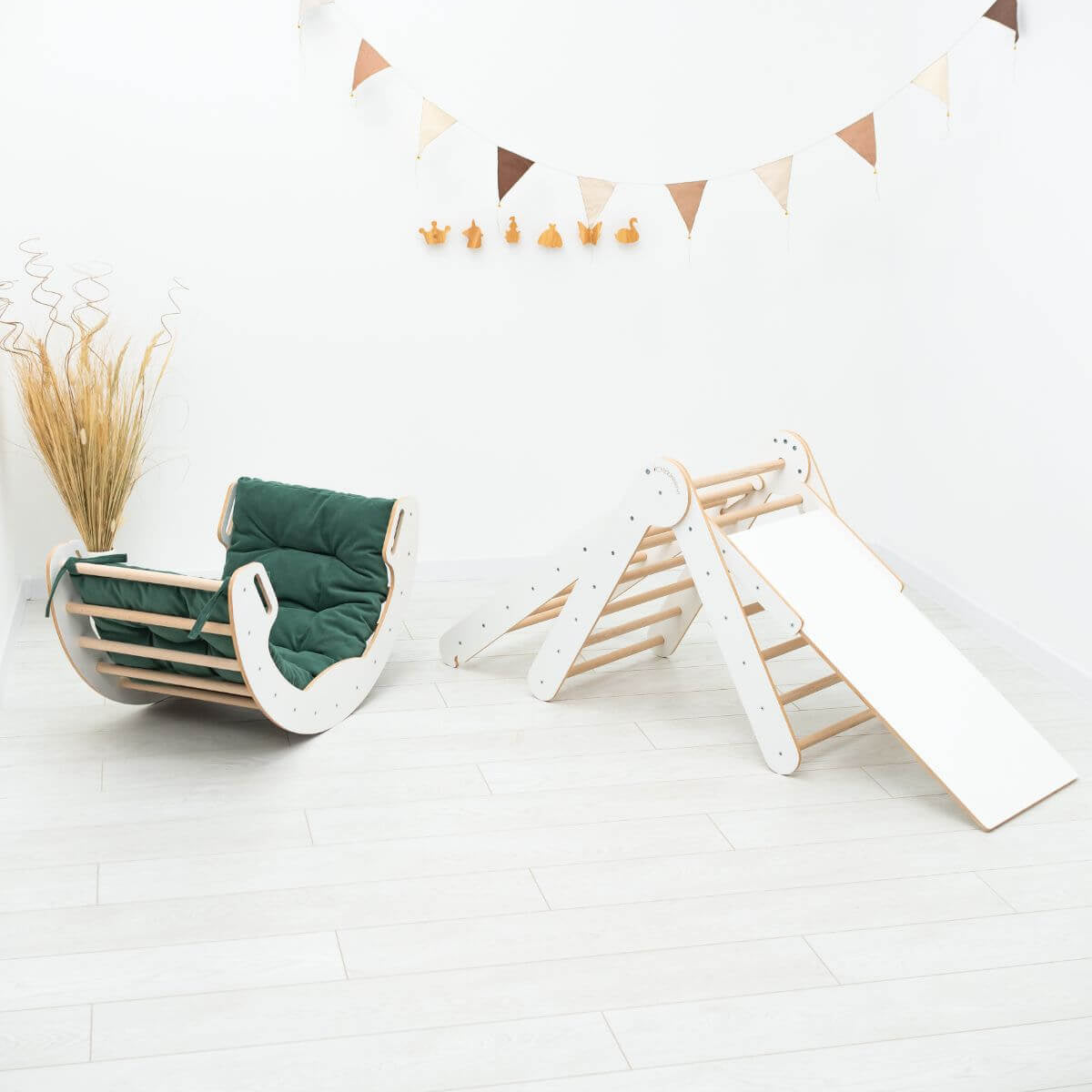 Children's play area with a green chair and white play tent on a light wooden floor.