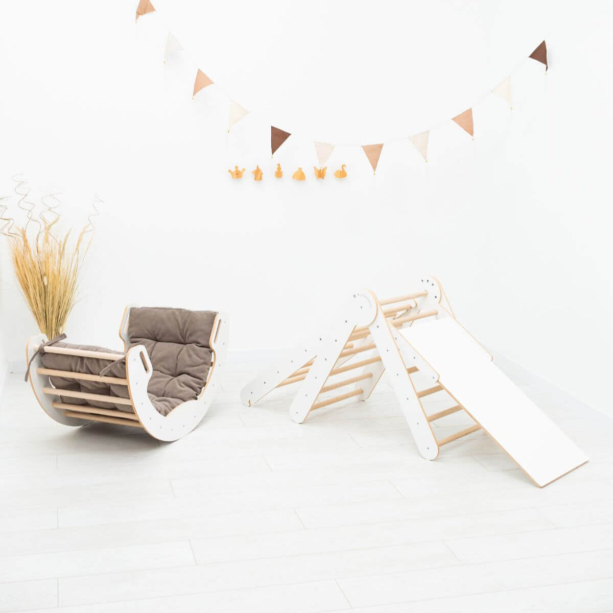 Children's play area with a swing, slide, and climbing wall on a white background