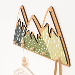 Decorative wall hook with mountain design on a white background