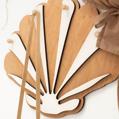 Wooden wall art with fan-like design on a white background