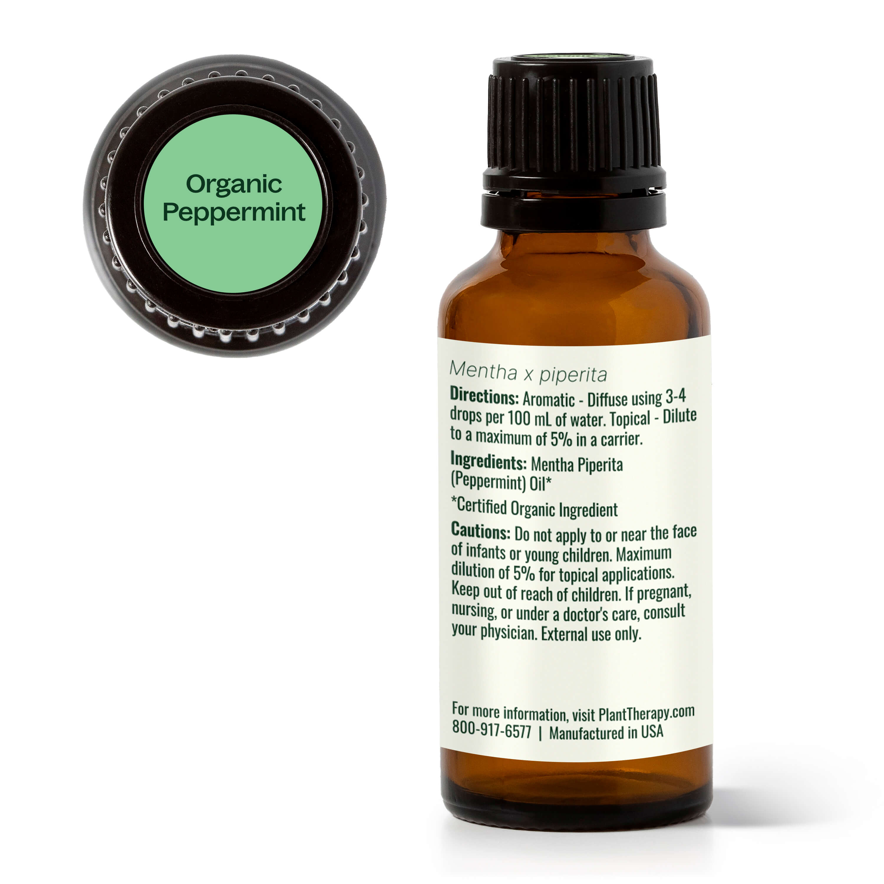 Bottle of organic peppermint essential oil with label and green cap on white background