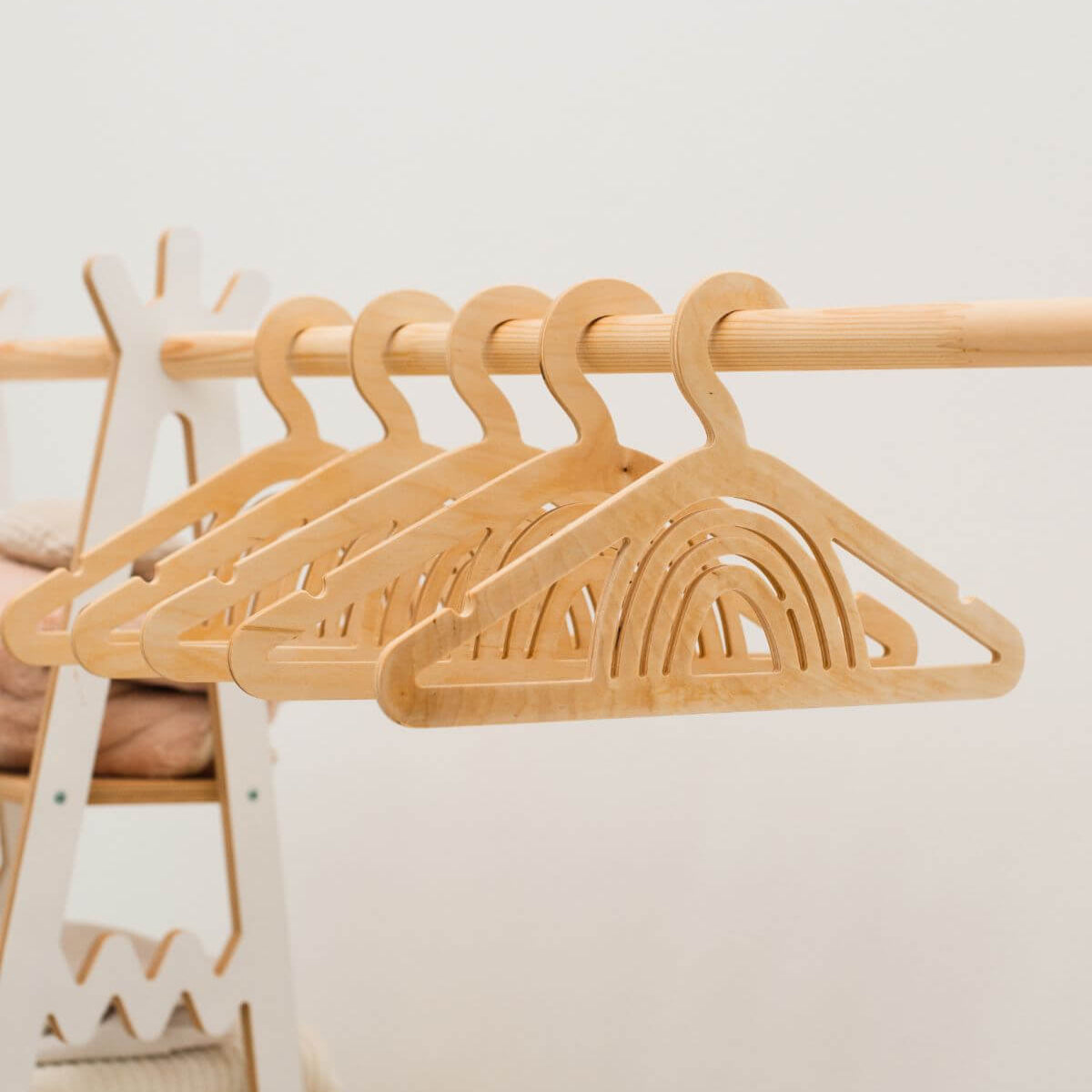 Set of wooden hangers on a rack with a neutral background