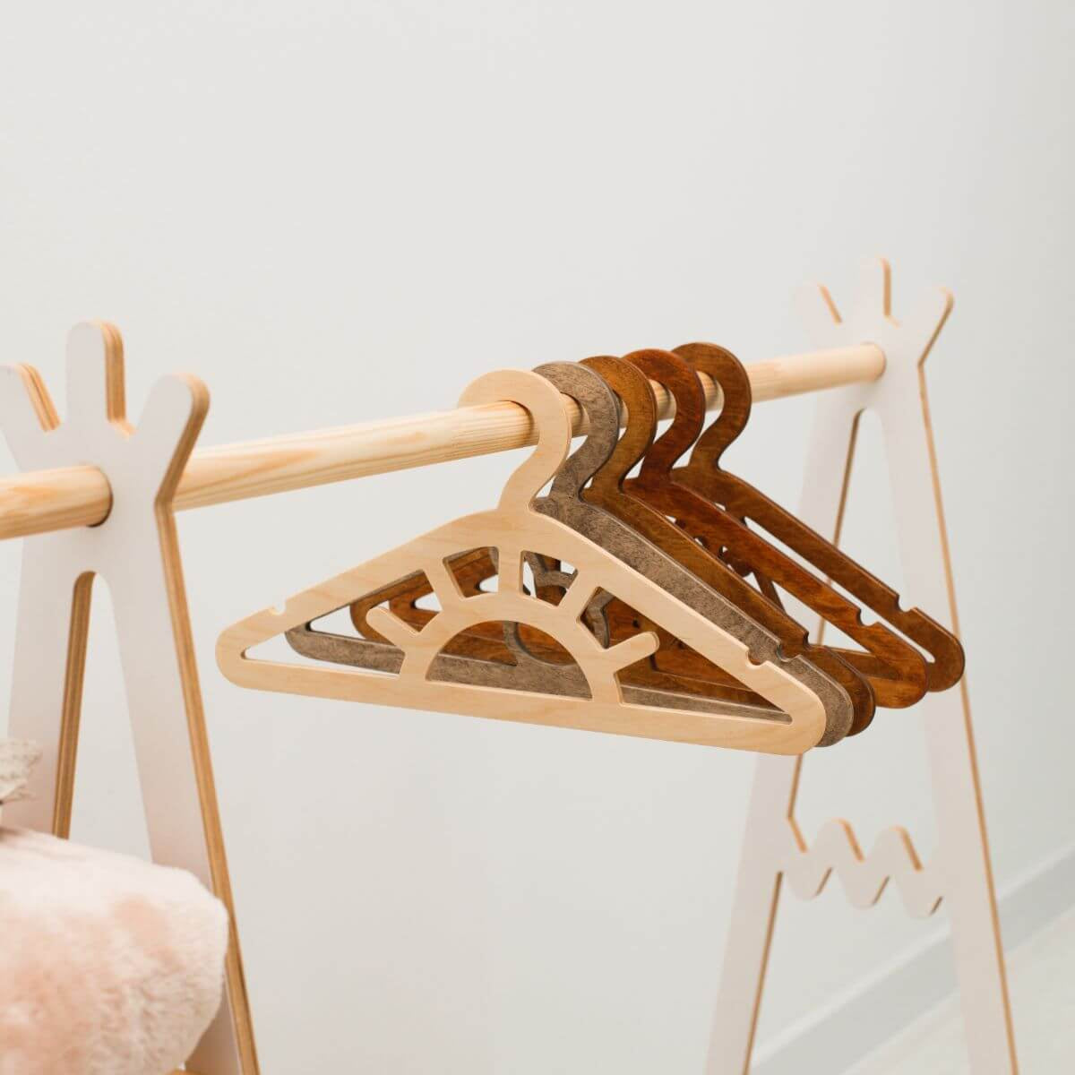 Set of wooden hangers on a rack against a light background