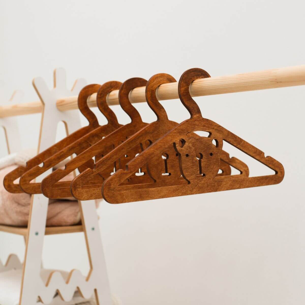 Set of wooden hangers on a rod with a neutral background