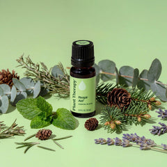 Essential oil bottle labeled 'Plant Therapy' surrounded by natural elements on a green background