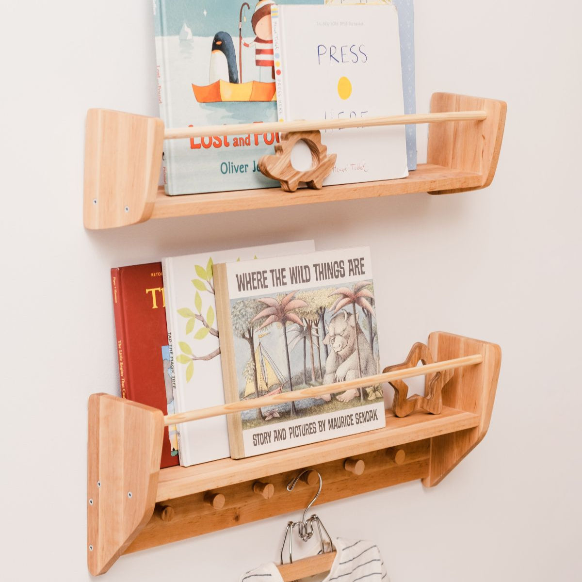 Wooden wall shelf with books and a small figurine on a white background