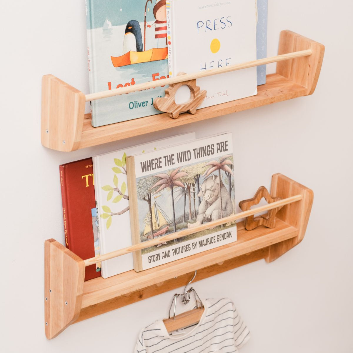 Wooden wall shelves with children's books and toys on a white wall
