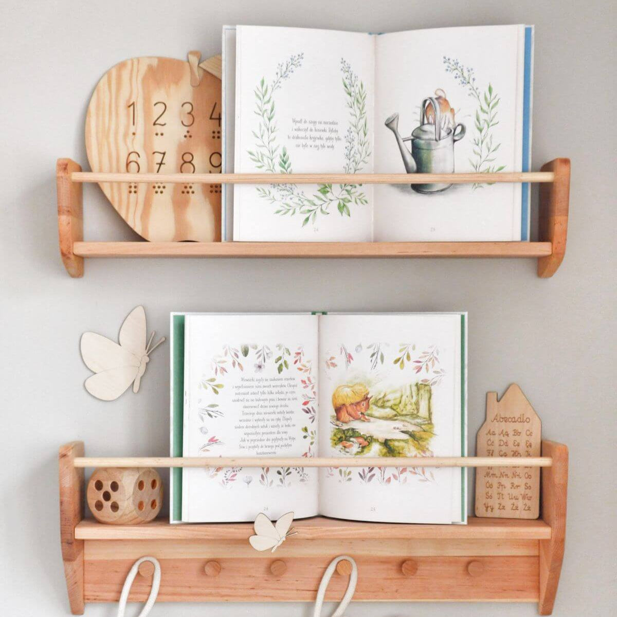 Wooden wall shelves with books and decorative items on a light gray background