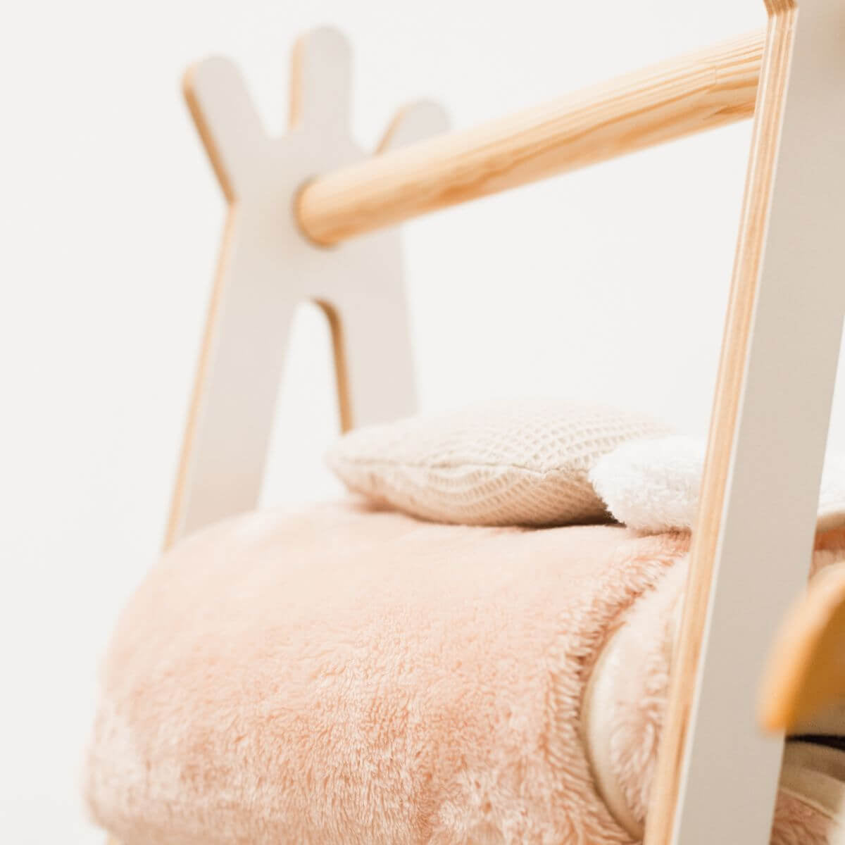 Close-up of a plush toy with a wooden frame on a light background