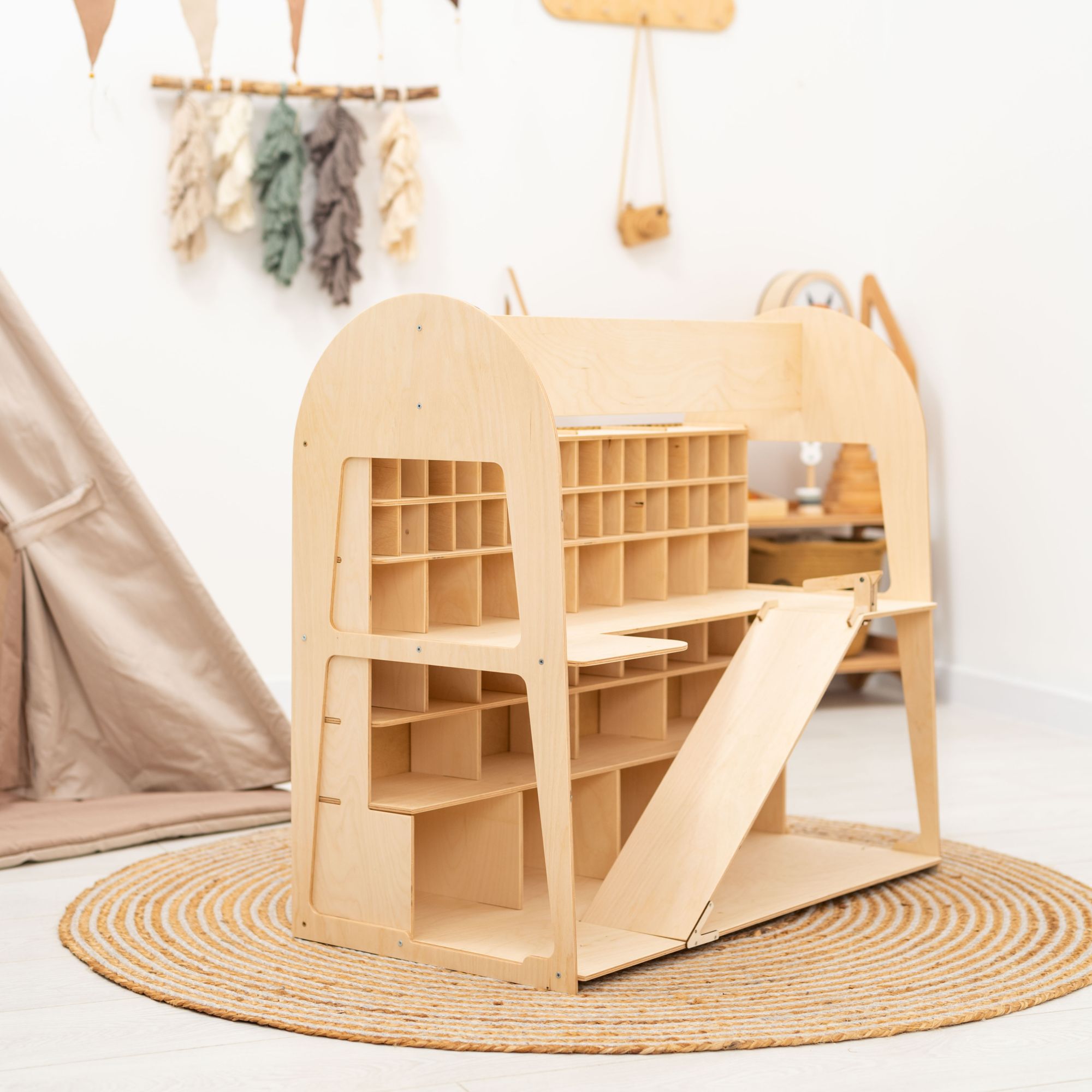 Wooden playhouse with shelves and a slide in a child's room