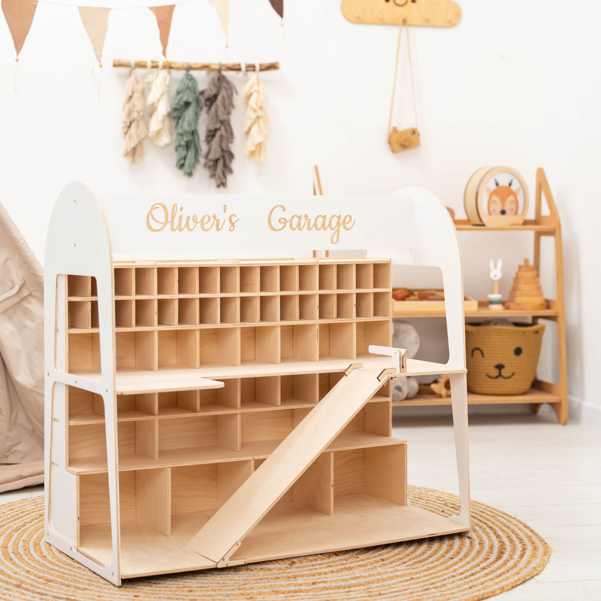 Wooden toy garage with 'Oliver's Garage' branding in a child's room.