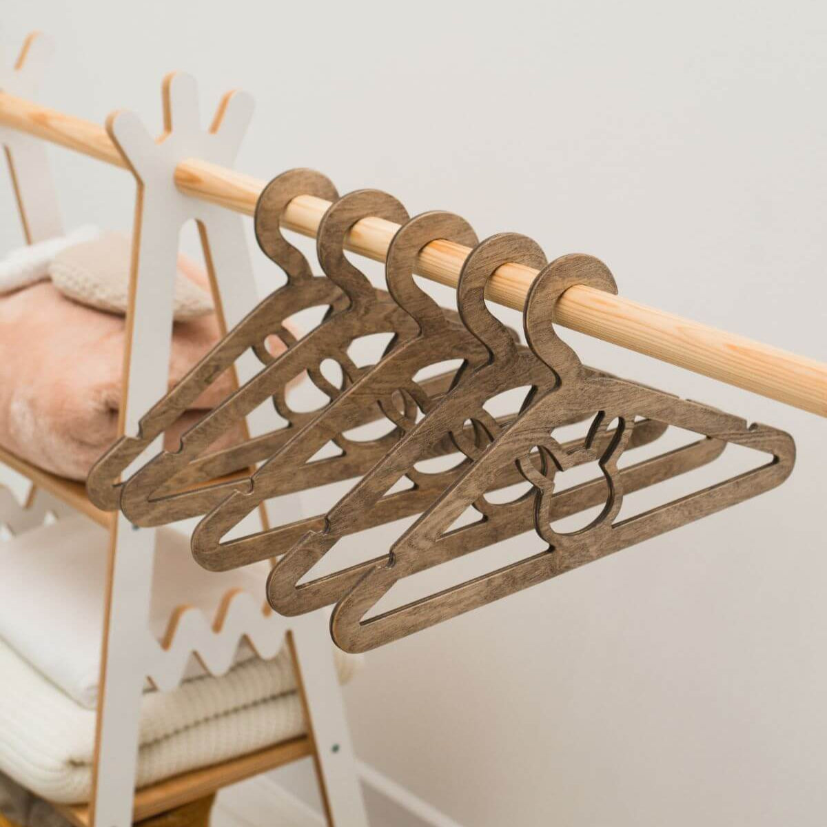 Set of wooden hangers on a rack with a neutral background