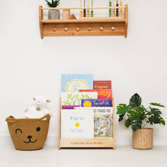 Children's books on a shelf with a basket and plants